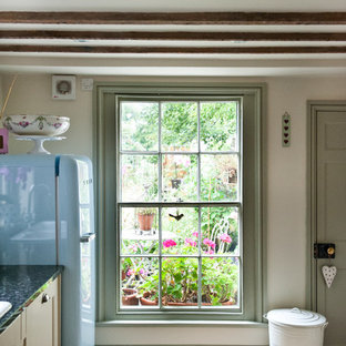Mid-sized country galley eat-in kitchen in Other with a drop-in sink, shaker cabinets, beige cabinets, granite benchtops, grey splashback, coloured appliances, travertine floors and no island.
