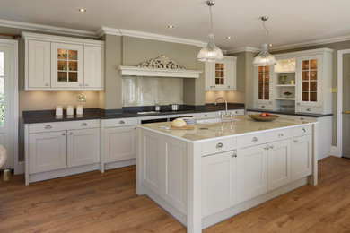 Photo of a large farmhouse l-shaped open plan kitchen in Other with shaker cabinets and an island.