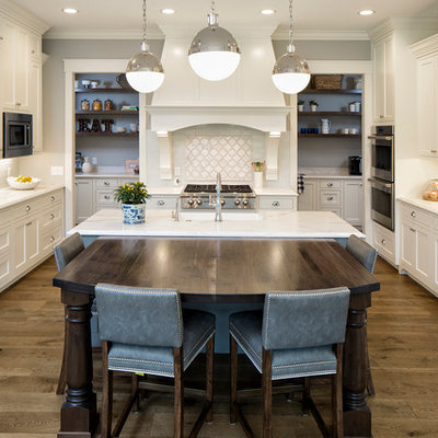Example of a large classic u-shaped medium tone wood floor open concept kitchen design in Minneapolis with a farmhouse sink, white cabinets, white backsplash, paneled appliances, an island, shaker cabinets, marble countertops and subway tile backsplash