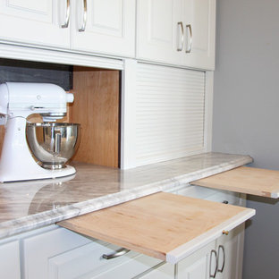 Esempio di un'ampia cucina ad ambiente unico shabby-chic style con lavello sottopiano, ante con bugna sagomata, ante bianche, top in granito, paraspruzzi grigio, paraspruzzi a specchio, elettrodomestici in acciaio inossidabile, pavimento in legno massello medio e isola