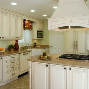 Farmhouse eat-in kitchen remodeling - Example of a farmhouse u-shaped eat-in kitchen design in Sacramento with an integrated sink, raised-panel cabinets, white cabinets, quartzite countertops, beige backsplash, stone slab backsplash, paneled appliances and no island