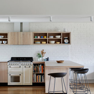 Inspiration for a mid-sized contemporary kitchen in Melbourne with a double-bowl sink, flat-panel cabinets, light wood cabinets, quartz benchtops, white splashback, porcelain splashback, white appliances, with island, beige benchtop, light hardwood floors and beige floor.