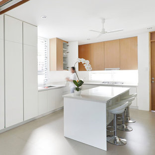 Mid-sized contemporary open concept kitchen designs - Example of a mid-sized trendy l-shaped gray floor and slate floor open concept kitchen design in New York with flat-panel cabinets, quartzite countertops, an island, an undermount sink, white cabinets, window backsplash, white appliances and white countertops