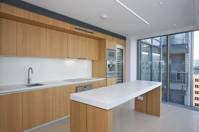 Diseño de cocina contemporánea de tamaño medio con armarios con paneles lisos, puertas de armario de madera oscura, salpicadero blanco y una isla