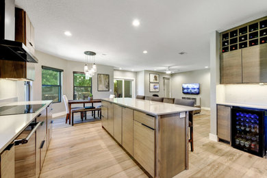 Example of a mid-sized trendy galley light wood floor and beige floor eat-in kitchen design in Austin with an undermount sink, flat-panel cabinets, medium tone wood cabinets, quartz countertops, glass sheet backsplash, black appliances, an island and gray countertops