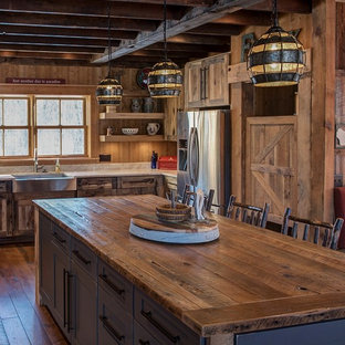 Rustic eat-in kitchen remodeling - Inspiration for a rustic u-shaped eat-in kitchen remodel in Minneapolis with a farmhouse sink, flat-panel cabinets, distressed cabinets, quartzite countertops, stainless steel appliances, an island and wood backsplash