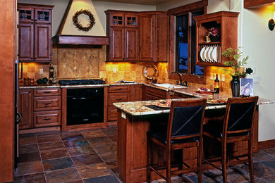 Mid-sized transitional u-shaped slate floor and brown floor eat-in kitchen photo in Denver with an undermount sink, raised-panel cabinets, medium tone wood cabinets, granite countertops, beige backsplash, stone tile backsplash, black appliances, an island and brown countertops
