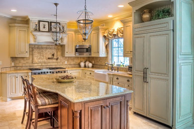 Mid-sized cottage l-shaped limestone floor eat-in kitchen photo in New York with a farmhouse sink, raised-panel cabinets, distressed cabinets, granite countertops, beige backsplash, ceramic backsplash, stainless steel appliances and an island