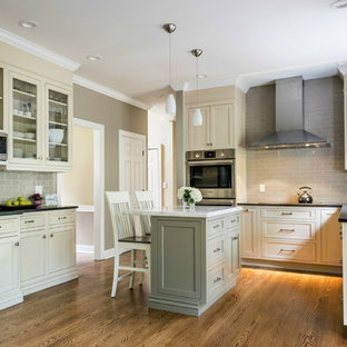 Design ideas for a small transitional u-shaped open plan kitchen in Other with an undermount sink, beaded inset cabinets, beige cabinets, grey splashback, ceramic splashback, stainless steel appliances, medium hardwood floors, with island, limestone benchtops and brown floor.