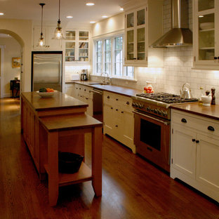 Large mediterranean eat-in kitchen designs - Example of a large tuscan l-shaped medium tone wood floor and brown floor eat-in kitchen design in Cincinnati with an undermount sink, shaker cabinets, white cabinets, granite countertops, white backsplash, ceramic backsplash, stainless steel appliances and an island