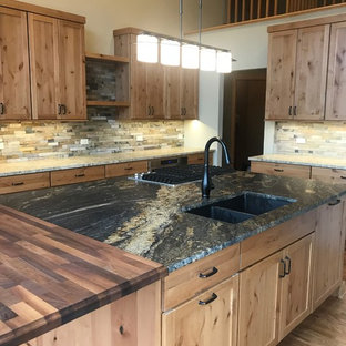 Photo of a large country l-shaped open plan kitchen in Chicago with an undermount sink, shaker cabinets, medium wood cabinets, granite benchtops, green splashback, slate splashback, stainless steel appliances, medium hardwood floors, with island, brown floor and black benchtop.
