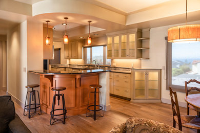 Exempel på ett mellanstort amerikanskt flerfärgad flerfärgat kök, med en nedsänkt diskho, skåp i shakerstil, orange skåp, granitbänkskiva, flerfärgad stänkskydd, stänkskydd i stenkakel, rostfria vitvaror, ljust trägolv, en halv köksö och brunt golv