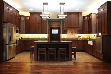 Inspiration for a mid-sized timeless u-shaped ceramic tile open concept kitchen remodel in St Louis with a farmhouse sink, flat-panel cabinets, dark wood cabinets, granite countertops, beige backsplash, stainless steel appliances and an island