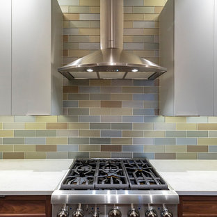 Small transitional enclosed kitchen ideas - Enclosed kitchen - small transitional l-shaped porcelain tile and brown floor enclosed kitchen idea in Other with an undermount sink, shaker cabinets, medium tone wood cabinets, quartz countertops, metallic backsplash, glass tile backsplash, stainless steel appliances, a peninsula and white countertops