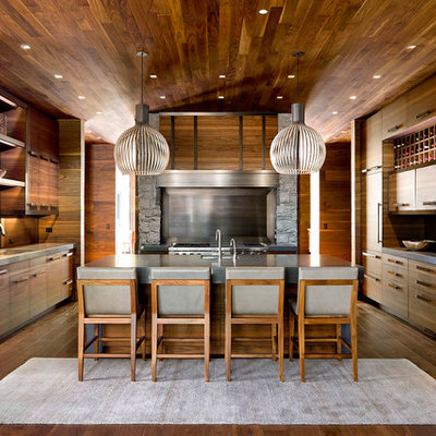 Inspiration for a large rustic u-shaped dark wood floor and brown floor eat-in kitchen remodel in Other with an undermount sink, flat-panel cabinets, dark wood cabinets, metallic backsplash, stainless steel appliances, an island, solid surface countertops and metal backsplash