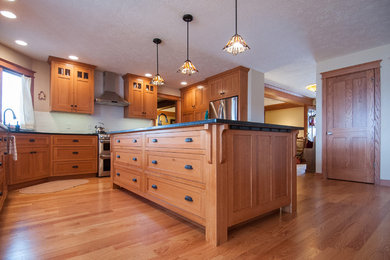 Open concept kitchen - large craftsman u-shaped light wood floor open concept kitchen idea in Other with shaker cabinets, medium tone wood cabinets, granite countertops, white backsplash, ceramic backsplash, stainless steel appliances and an island