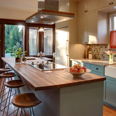 Example of a mid-sized classic galley medium tone wood floor eat-in kitchen design in Los Angeles with a farmhouse sink, quartz countertops, multicolored backsplash, beige cabinets, shaker cabinets, ceramic backsplash, an island and paneled appliances