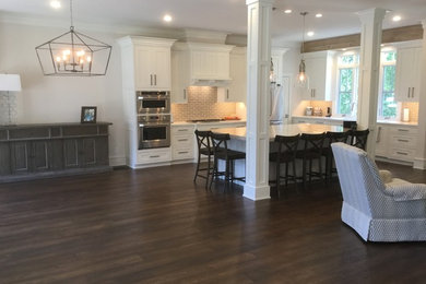 Mid-sized arts and crafts l-shaped dark wood floor open concept kitchen photo in Birmingham with an undermount sink, flat-panel cabinets, white cabinets, quartzite countertops, beige backsplash, porcelain backsplash, stainless steel appliances and an island