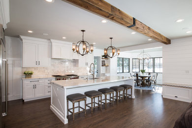 Example of an arts and crafts l-shaped medium tone wood floor and brown floor eat-in kitchen design in Chicago with an undermount sink, shaker cabinets, white cabinets, quartz countertops, gray backsplash, marble backsplash, stainless steel appliances and an island