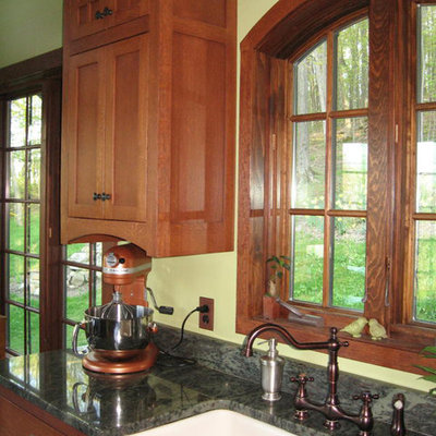 Inspiration for a mid-sized craftsman u-shaped porcelain tile eat-in kitchen remodel in New York with a farmhouse sink, flat-panel cabinets, medium tone wood cabinets, granite countertops, brown backsplash, stone slab backsplash, white appliances and a peninsula