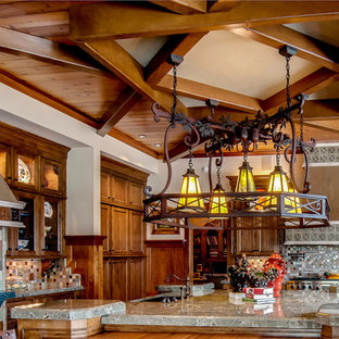 Large craftsman eat-in kitchen inspiration - Large arts and crafts u-shaped medium tone wood floor and brown floor eat-in kitchen photo in San Diego with a farmhouse sink, recessed-panel cabinets, medium tone wood cabinets, granite countertops, green backsplash, terra-cotta backsplash, paneled appliances, an island and green countertops