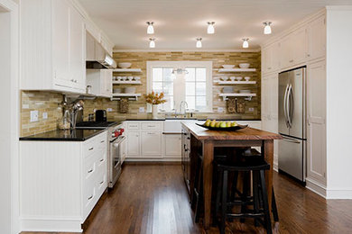 Klassisk inredning av ett mellanstort u-kök, med en rustik diskho, öppna hyllor, vita skåp, granitbänkskiva, grönt stänkskydd, stänkskydd i keramik, rostfria vitvaror, mellanmörkt trägolv och en köksö