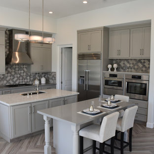 Inspiration for a large arts and crafts l-shaped open plan kitchen in San Francisco with a single-bowl sink, shaker cabinets, grey cabinets, quartz benchtops, grey splashback, mosaic tile splashback, stainless steel appliances, ceramic floors and multiple islands.