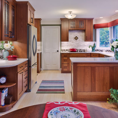 Large arts and crafts u-shaped bamboo floor eat-in kitchen photo in Detroit with an undermount sink, shaker cabinets, medium tone wood cabinets, quartzite countertops, beige backsplash, stone tile backsplash, stainless steel appliances and a peninsula