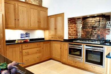 Classic kitchen in Other with beaded cabinets, light wood cabinets, granite worktops and black splashback.