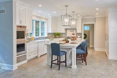 Transitional ceramic tile kitchen photo in New York with a farmhouse sink, recessed-panel cabinets, white cabinets, gray backsplash, subway tile backsplash, stainless steel appliances and an island