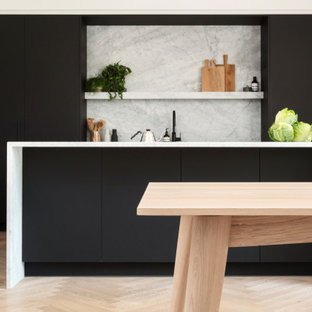 Ispirazione per una cucina scandinava di medie dimensioni con lavello sottopiano, ante lisce, ante nere, top in marmo, paraspruzzi grigio, paraspruzzi in marmo, elettrodomestici neri, parquet chiaro, isola, pavimento marrone, top grigio e soffitto in carta da parati