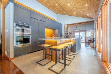 Photo of a contemporary galley kitchen in Vancouver with a submerged sink, flat-panel cabinets, grey cabinets, yellow splashback, integrated appliances, an island, beige floors, multicoloured worktops and a wood ceiling.