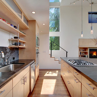 Inspiration for a modern open plan kitchen in Seattle with a single-bowl sink, open cabinets, light wood cabinets, black splashback, stone slab splashback and stainless steel appliances.