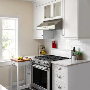 Cette image montre une petit cuisine traditionnelle avec un placard à porte shaker, des portes de placard blanches, un plan de travail en quartz modifié, une crédence blanche, une crédence en carrelage métro, un électroménager en acier inoxydable et un sol en vinyl.