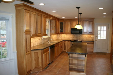 Exempel på ett avskilt, mellanstort klassiskt u-kök, med en dubbel diskho, luckor med upphöjd panel, skåp i mellenmörkt trä, beige stänkskydd, stänkskydd i keramik, rostfria vitvaror, klinkergolv i terrakotta och en köksö