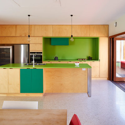 Example of a trendy galley beige floor open concept kitchen design in Adelaide with a double-bowl sink, flat-panel cabinets, beige cabinets, green backsplash, stainless steel appliances, an island and green countertops
