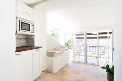 Cette photo montre une cuisine linéaire tendance de taille moyenne et fermée avec des portes de placard blanches et aucun îlot.