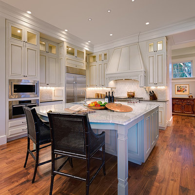 Kitchen - traditional kitchen idea in Charleston with white cabinets, white backsplash and limestone backsplash