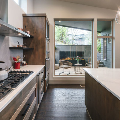 Inspiration for a mid-sized rustic u-shaped dark wood floor and brown floor eat-in kitchen remodel in Portland with a drop-in sink, shaker cabinets, brown cabinets, quartz countertops, gray backsplash, ceramic backsplash, stainless steel appliances, an island and white countertops