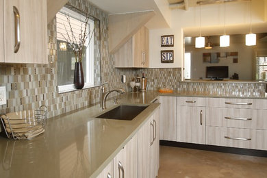 Mid-sized trendy u-shaped concrete floor and brown floor open concept kitchen photo in New Orleans with an undermount sink, flat-panel cabinets, light wood cabinets, solid surface countertops, beige backsplash, glass tile backsplash, a peninsula and brown countertops