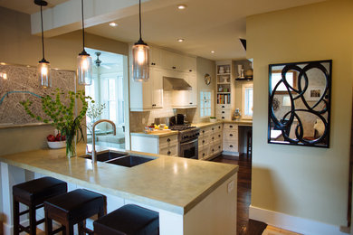 Bild på ett avskilt, mellanstort funkis l-kök, med en dubbel diskho, luckor med infälld panel, beige skåp, bänkskiva i betong, beige stänkskydd, stänkskydd i keramik, rostfria vitvaror, mörkt trägolv och en köksö