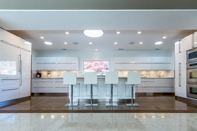 セントルイスにあるコンテンポラリースタイルのおしゃれなキッチン (アンダーカウンターシンク、マルチカラーのキッチンパネル、パネルと同色の調理設備、コンクリートの床、白いキャビネット) の写真