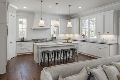 Inspiration for a huge transitional dark wood floor and brown floor kitchen remodel in Nashville with a single-bowl sink, shaker cabinets, white cabinets, granite countertops, white backsplash, stainless steel appliances and an island