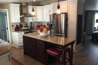 Mid-sized transitional u-shaped medium tone wood floor eat-in kitchen photo in Other with an undermount sink, flat-panel cabinets, dark wood cabinets, quartz countertops, beige backsplash, stone tile backsplash, stainless steel appliances and an island