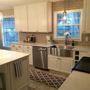 Mid-sized traditional enclosed kitchen ideas - Mid-sized elegant l-shaped ceramic tile enclosed kitchen photo in Jacksonville with a farmhouse sink, raised-panel cabinets, white cabinets, quartzite countertops, beige backsplash, subway tile backsplash, stainless steel appliances and an island