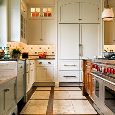 Eat-in kitchen - traditional multicolored floor eat-in kitchen idea in New York with a farmhouse sink, recessed-panel cabinets, white cabinets, granite countertops, paneled appliances, multicolored backsplash and ceramic backsplash