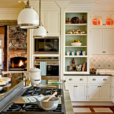 Example of a classic eat-in kitchen design in New York with recessed-panel cabinets, stainless steel appliances, white cabinets, granite countertops, multicolored backsplash, a farmhouse sink and ceramic backsplash