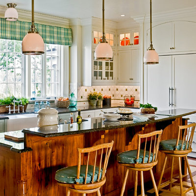Inspiration for a timeless eat-in kitchen remodel in New York with paneled appliances, a farmhouse sink, white cabinets, granite countertops, multicolored backsplash, recessed-panel cabinets and ceramic backsplash