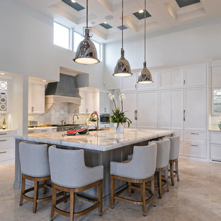 Foto di un'ampia cucina classica con ante di vetro, ante bianche, paraspruzzi bianco, elettrodomestici in acciaio inossidabile, isola, pavimento beige, top in marmo, paraspruzzi in gres porcellanato e top bianco