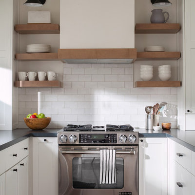Example of a beach style u-shaped dark wood floor kitchen design in San Francisco with shaker cabinets, white cabinets, white backsplash, subway tile backsplash, stainless steel appliances and gray countertops